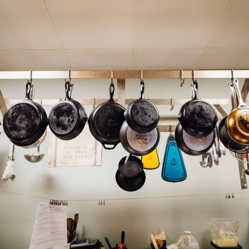 Frying pans hanging from a pot rack. Illustrative stock photograph, not a photograph of the reviewed pan.