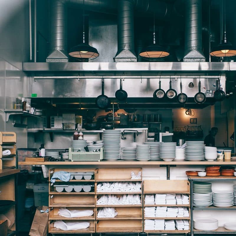 A stack of stainless steel pots and pans in a kitchen. Illustrative stock photograph, not a photograph of the reviewed set.