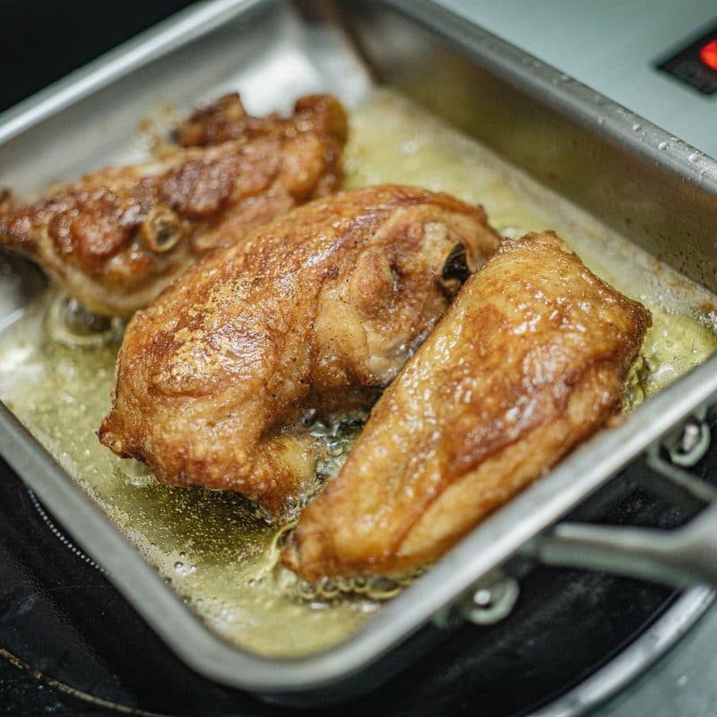 Food frying in hot oil in a stainless steel pan. Illustrative stock photograph, not a photograph of the reviewed pan.